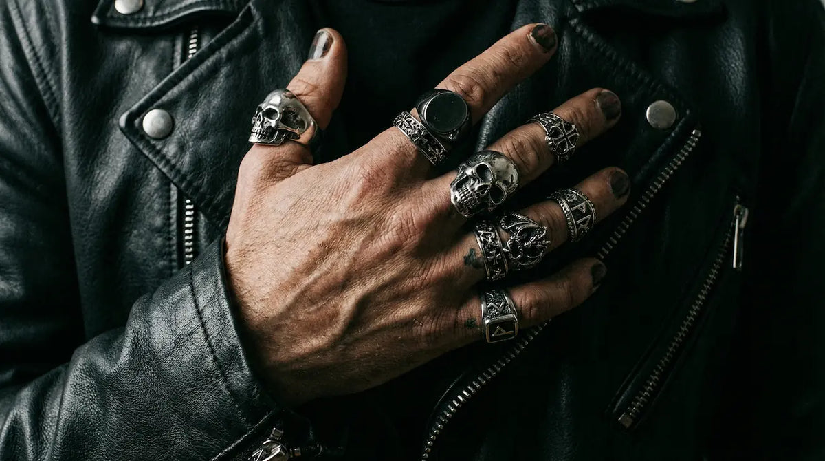Man wearing stacked gothic skull and signet rings with a black leather jacket