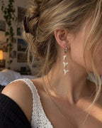 Three-tooth Abyss Fang shark tooth earring worn in side profile with the hair tied back