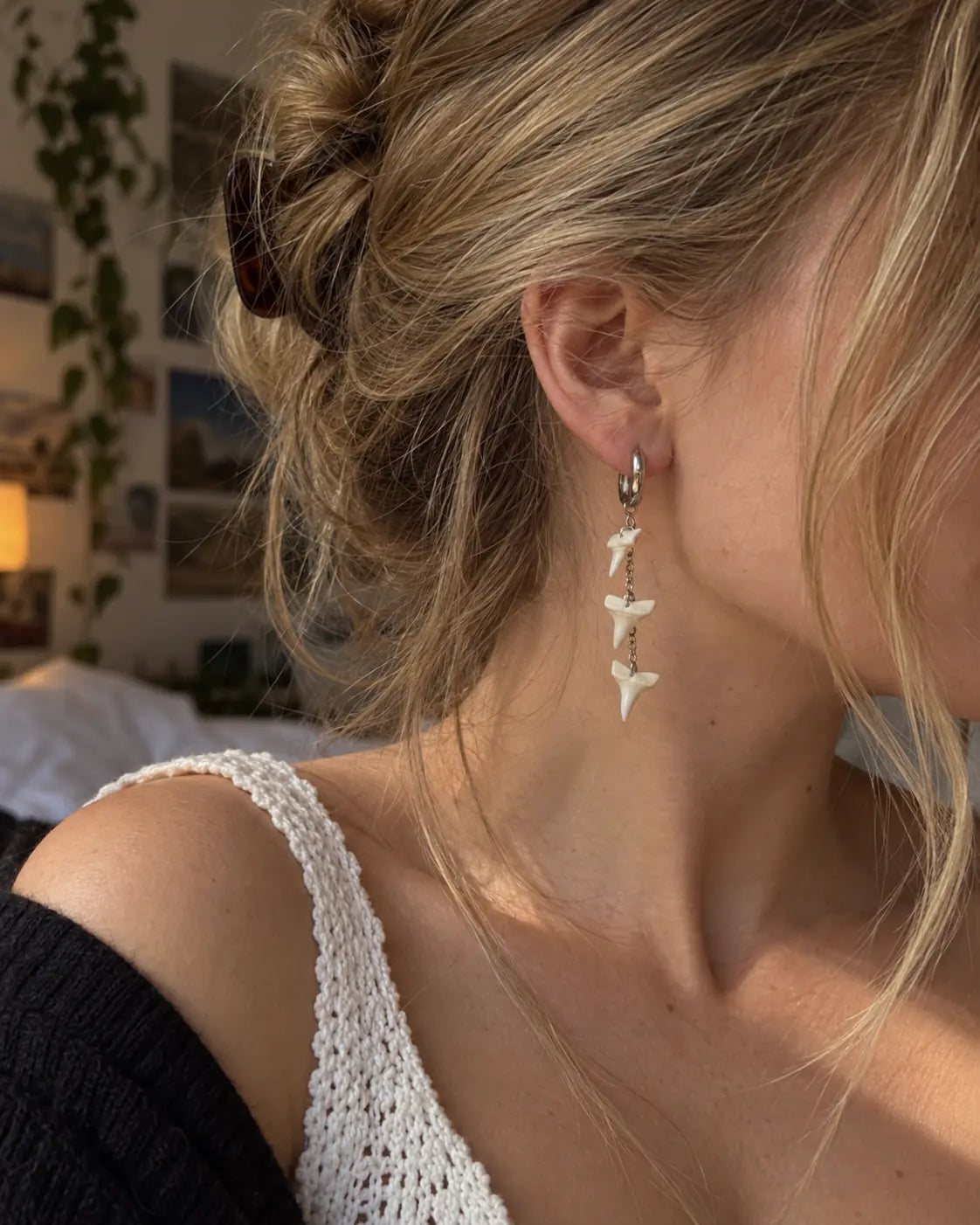 Three-tooth Abyss Fang shark tooth earring worn in side profile with the hair tied back