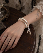 Apricot Glow snake bone bracelet worn in two rows on a wrist resting on a wooden table
