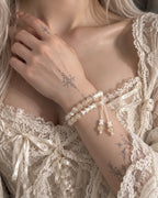 Apricot Glow snake bone bracelet worn with the hand at the collarbone, showing white cords and peach bead tips