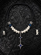 Azure Twin Star snake bone necklace with blue beads and two hanging silver-tone stars with blue centers on black fabric