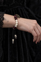 Side view of the Bagua Coin snake bone bracelet on the wrist, with its two bone- and metal-tipped cords hanging down
