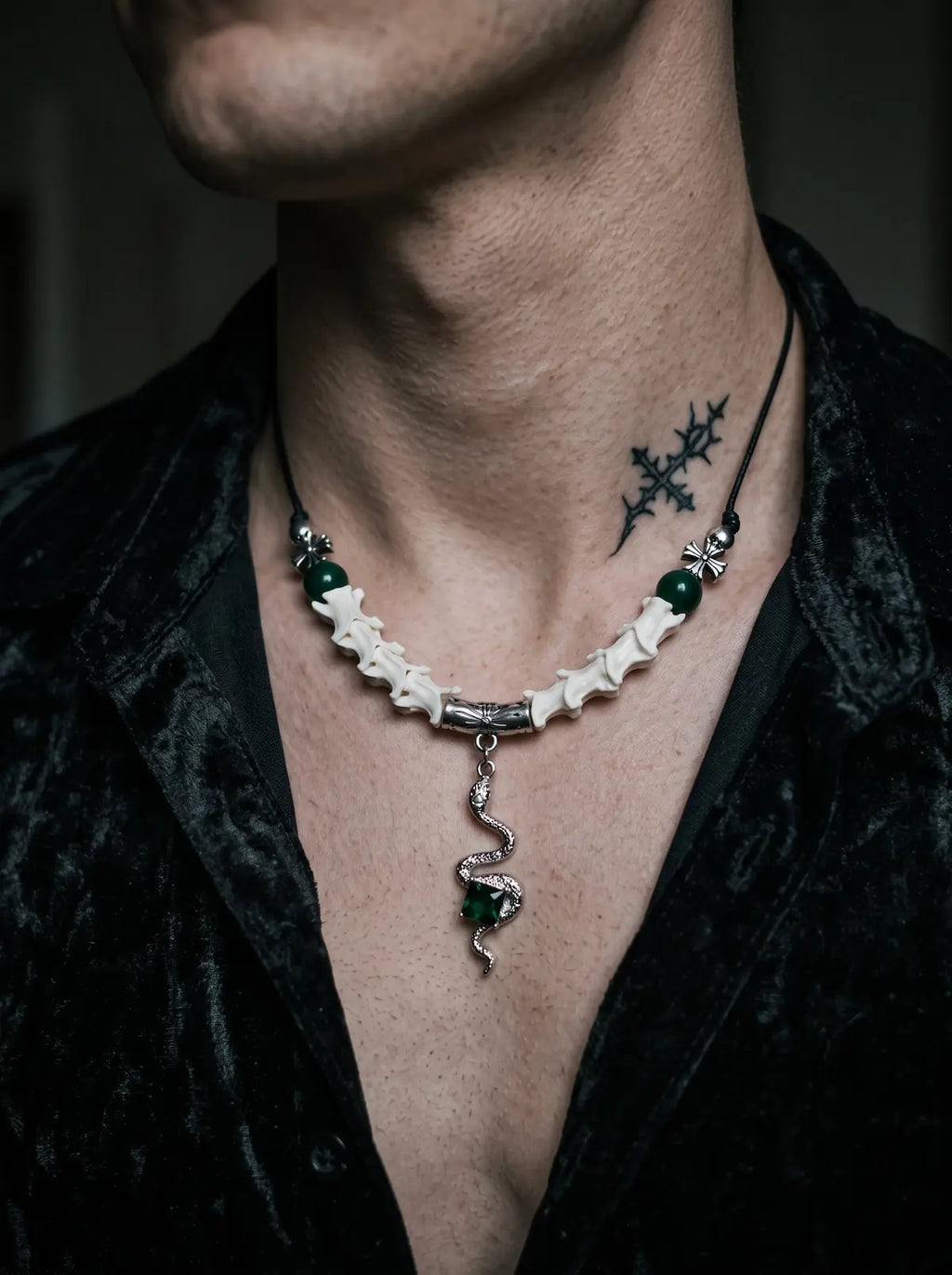 Basilisk Jewel Snake Bone Necklace, coiled serpent pendant necklace worn above a dark collared shirt