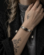 Black Orb snake bone bracelet shown on a raised wrist near the collar, with its black bead and square spacers visible