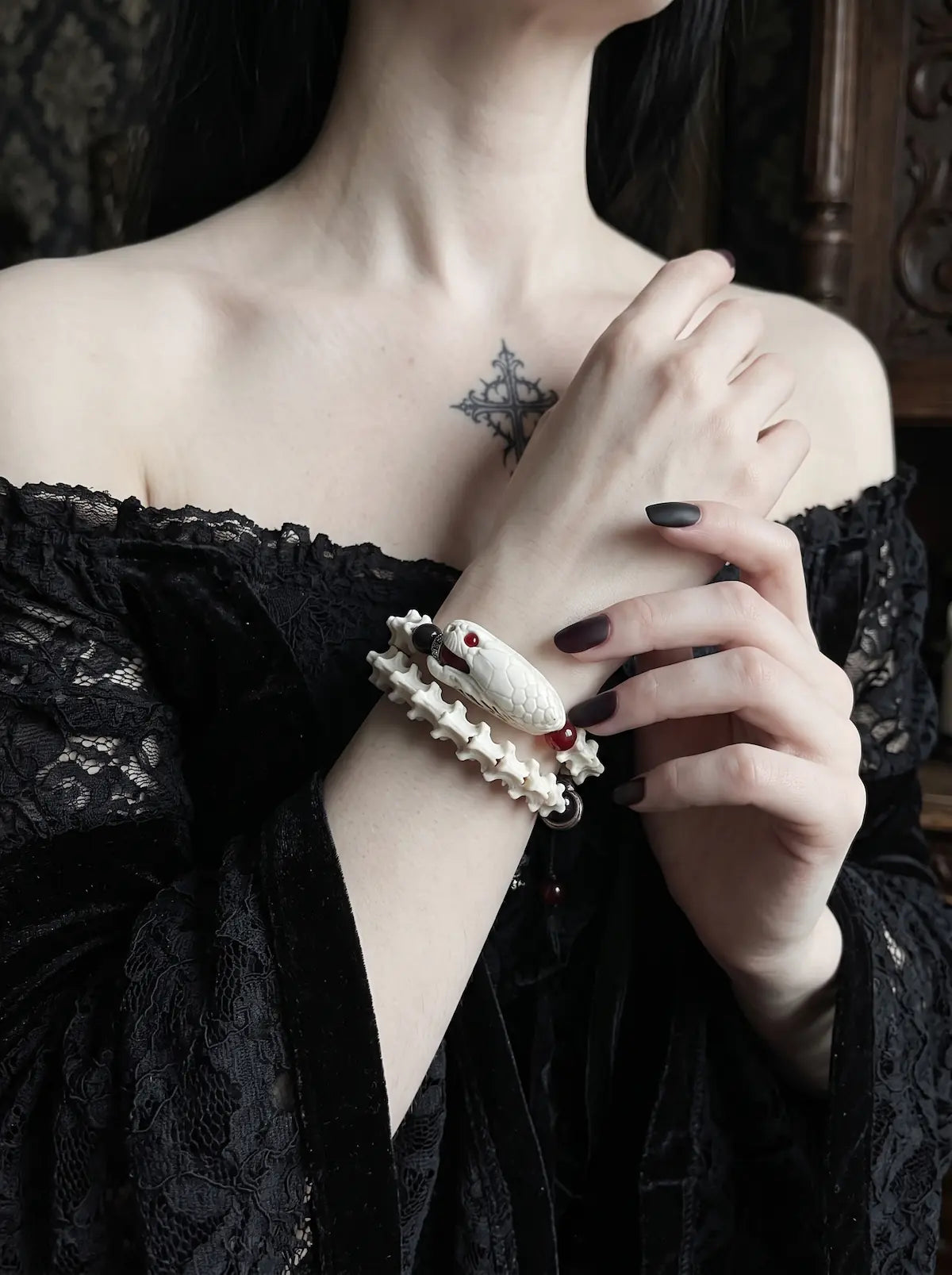 Bloodgaze Snake Bone Bracelet, close view of a wrist wearing the pale vertebrae bracelet with red bead details