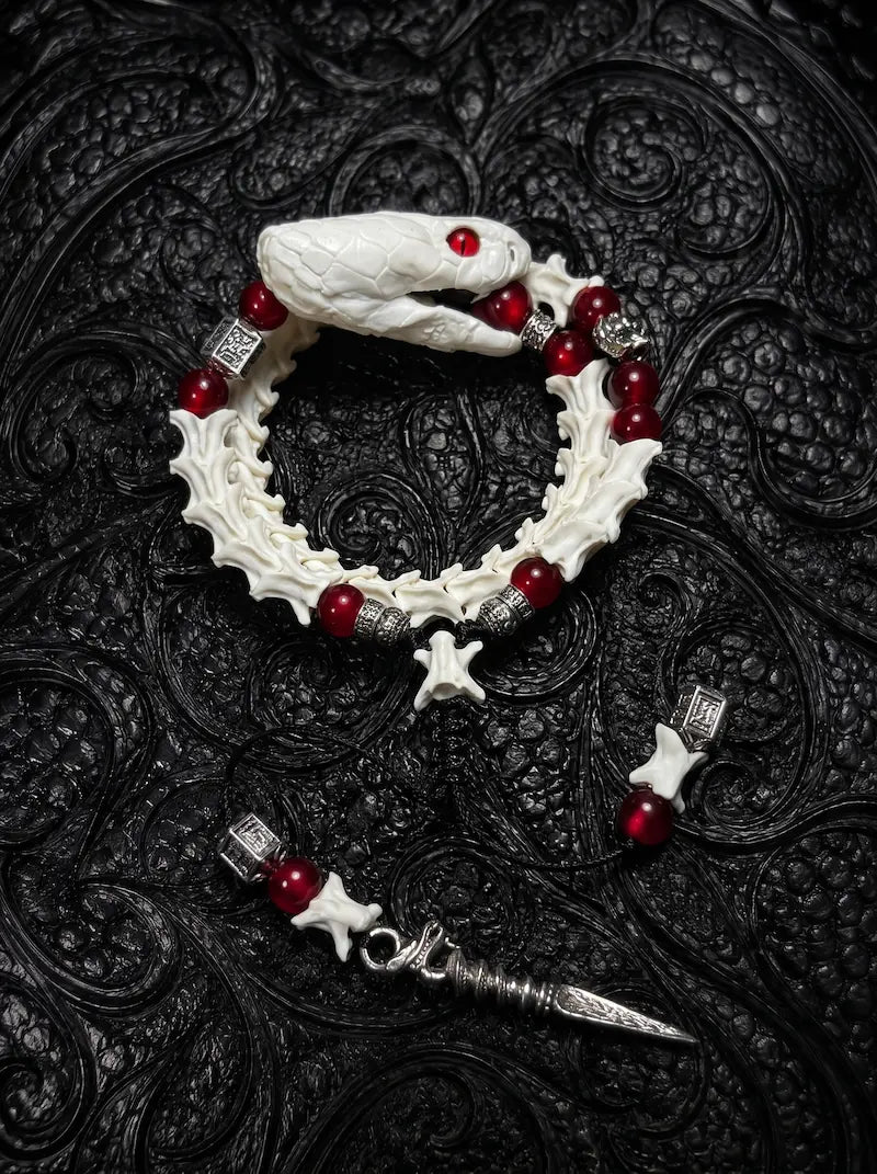 Bloodlance Snake Bone Bracelet, pale preserved snake head bracelet with red bead accents and pointed metal drops