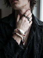 Bloodlance Snake Bone Bracelet, red accented snake bone bracelet on the wrist while the model touches the neck