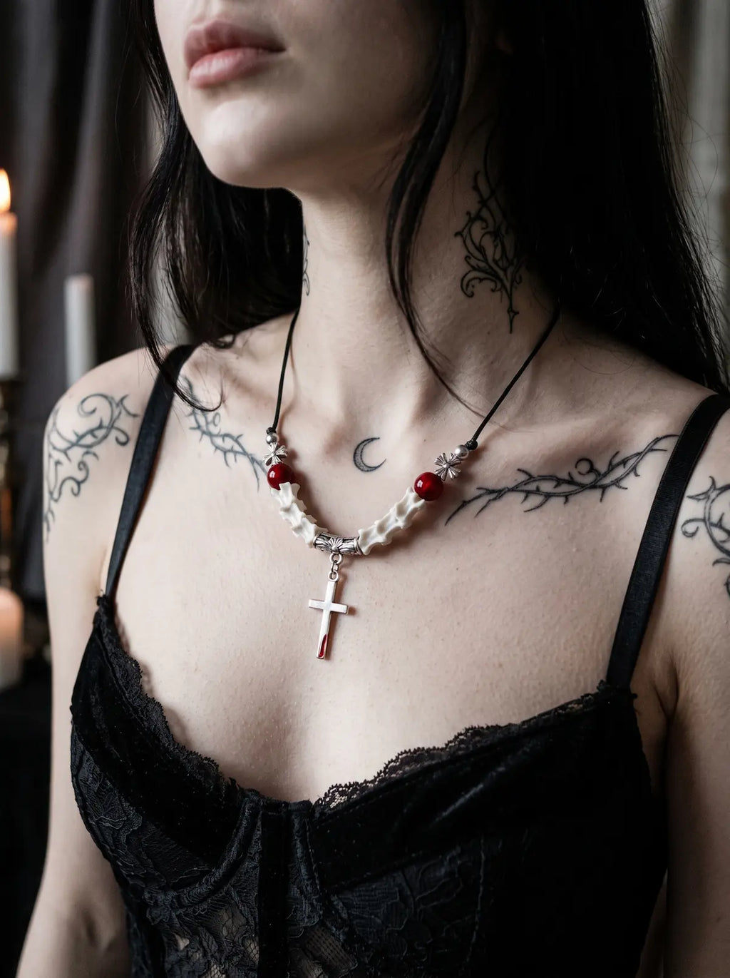 Bloodmark Cross Snake Bone Necklace, red bead and pale snake bone cross necklace worn with a black lace top