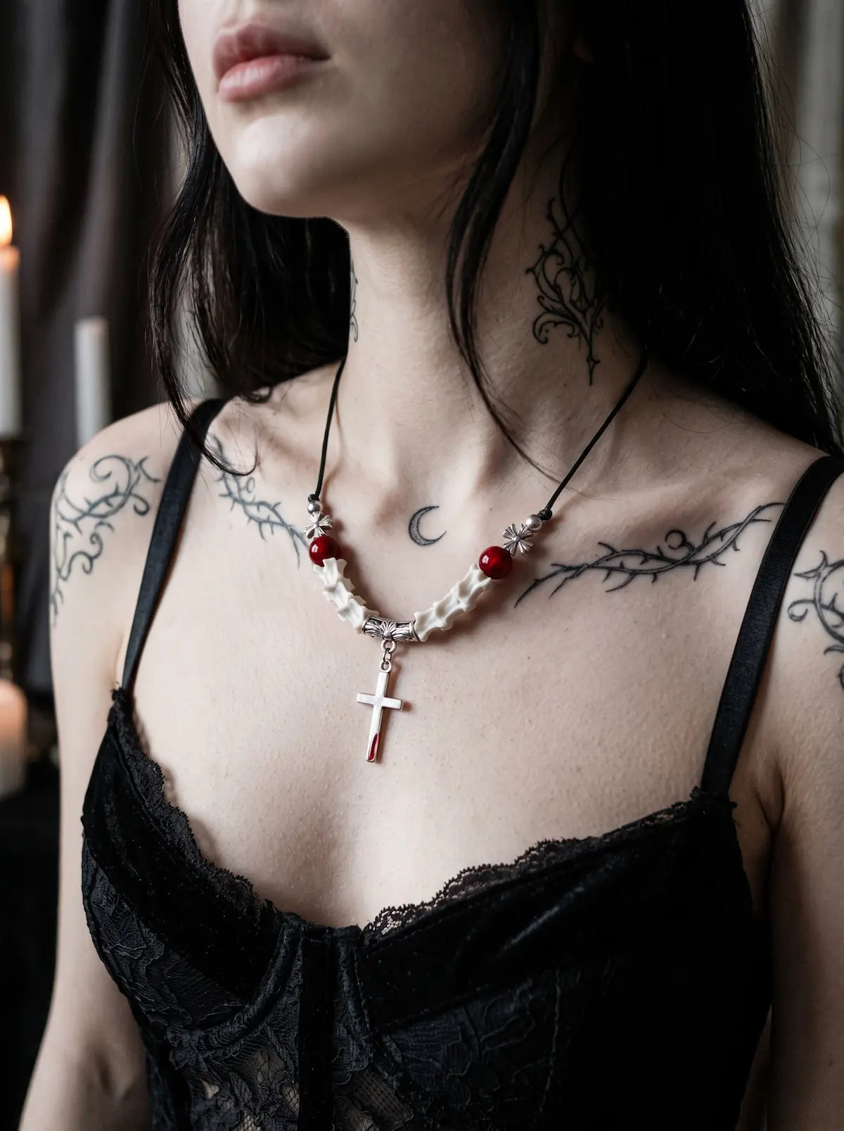 Bloodmark Cross Snake Bone Necklace, red bead and pale snake bone cross necklace worn with a black lace top