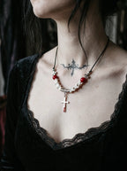 Bloodmark Cross Snake Bone Necklace, close collarbone view of red accents and cross below pale vertebrae