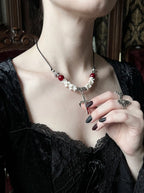 Bloodmark Cross Snake Bone Necklace, red bead and white vertebrae necklace with cross worn at the neckline