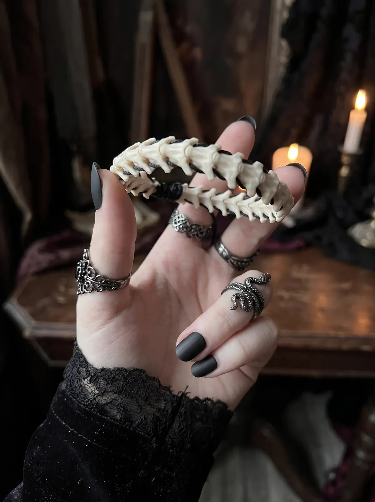 Bonebound Snake Bone Bracelet, snake bone bracelet held between fingers, showing the segmented vertebrae design