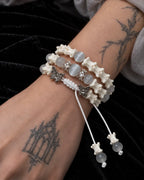 Close-up of the Butterfly Mist snake bone bracelet showing gray beads, butterfly accents and its white braided knot