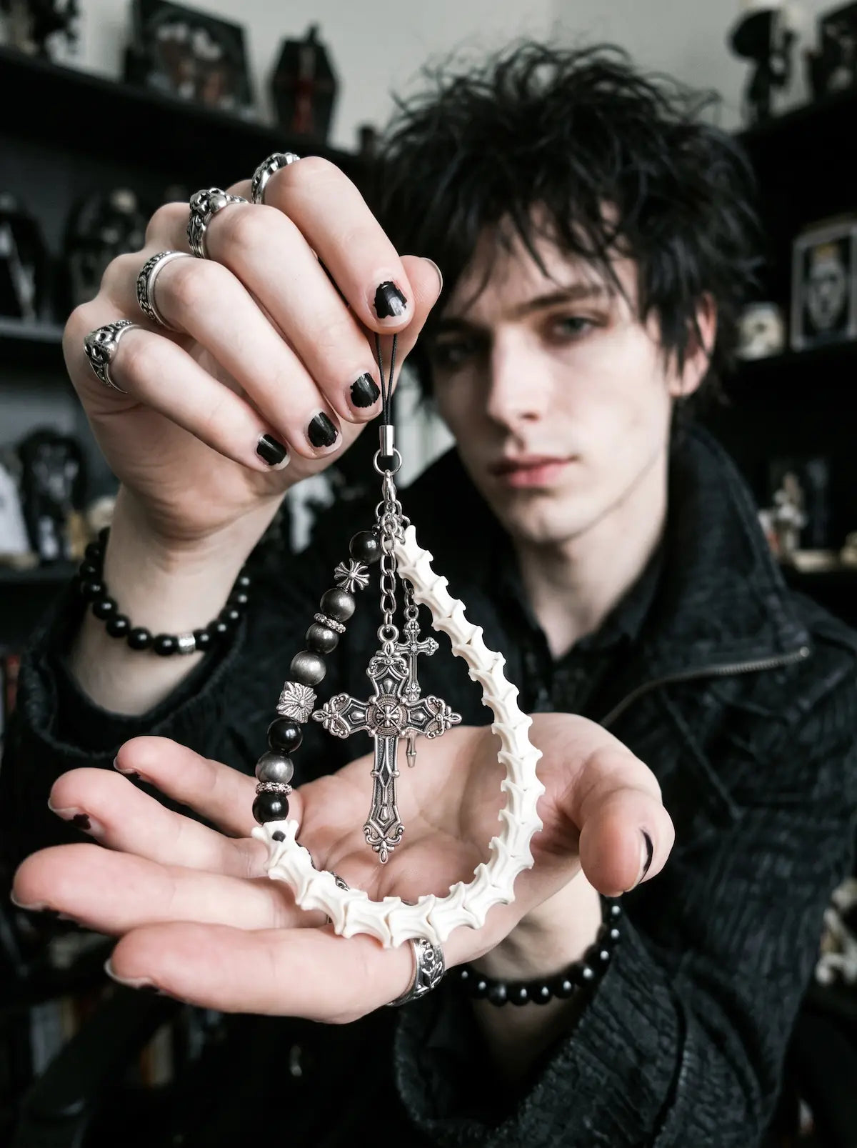 Cathedral Relic Snake Bone Keychain, white snake bone keychain with cross and metal charms hanging on a light bag