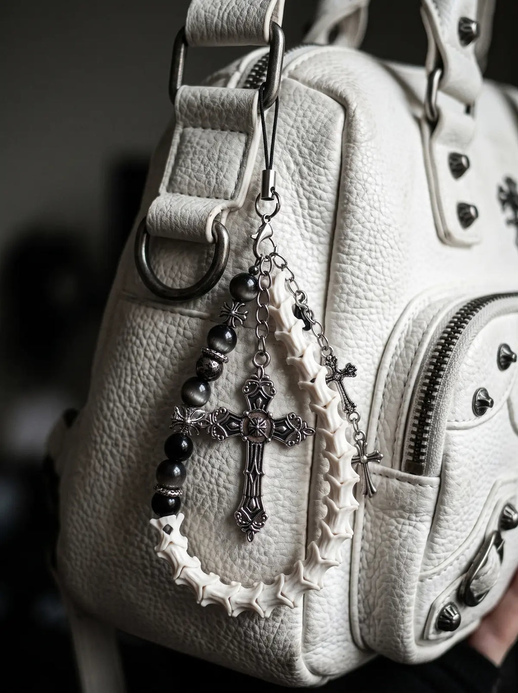 Cathedral Relic Snake Bone Keychain, snake bone and silver-tone cross keychain held in a hand to show the full loop