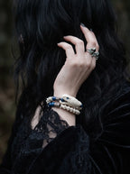 Cobalt Batwing Snake Bone Bracelet, wrist wearing white bone bracelet with bright blue beads and dangling charms