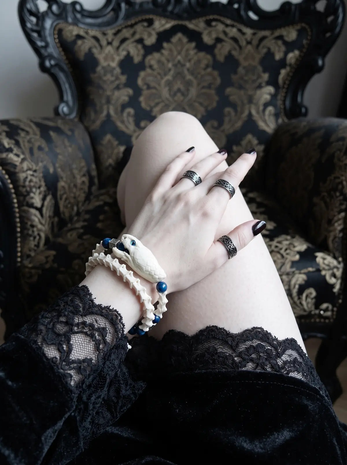 Cobalt Batwing Snake Bone Bracelet, close wrist detail of snake head bracelet with cobalt beads and black lace sleeve