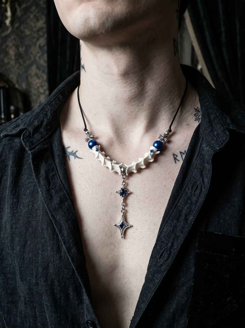 Cobalt Starfall Snake Bone Necklace, snake bone necklace with cobalt-blue bead accents on a model in black