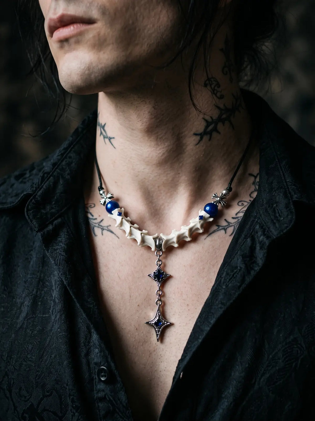 Cobalt Starfall Snake Bone Necklace, side chest view of cobalt beads and silver-tone star pendant over an open shirt