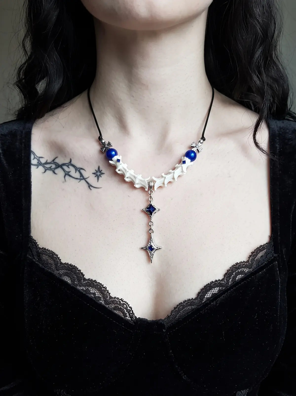 Cobalt Starfall Snake Bone Necklace, blue and white snake bone necklace worn above a black lace neckline