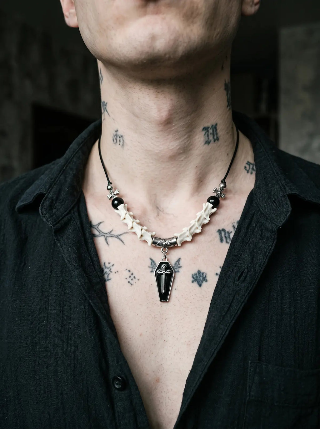 Coffin Oath Snake Bone Necklace, close view of engraved coffin pendant hanging from the white bone necklace