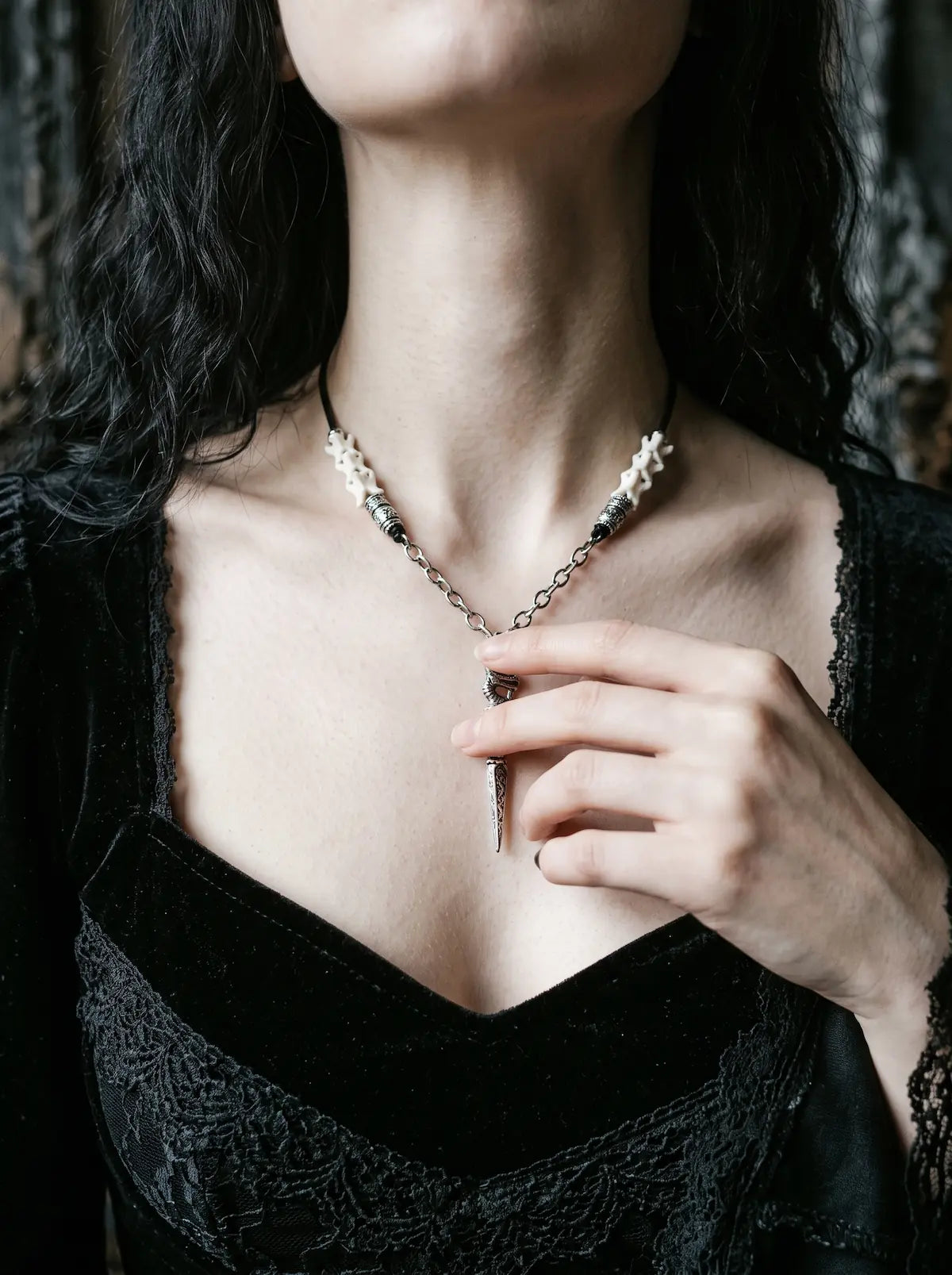 Coilblade Snake Bone Necklace, close front neck view showing the pointed blade pendant below white vertebrae