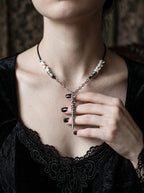 Coilblade Snake Bone Necklace, white bone necklace with dagger charm worn above a black velvet neckline