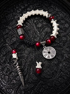 Crimson Coin snake bone bracelet with deep red beads, an engraved round coin and a long pointed metal drop on black cords
