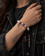 Crimson Cross snake bone bracelet worn with the hand holding a black denim jacket collar