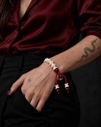 Crimson Spine snake bone bracelet worn with the hand tucked into a black trouser pocket