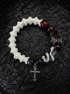 Crimson Thorn snake bone bracelet with red and smoky black beads, a dark rose, silver-tone serpent and cross charm