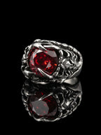 Dragon Talon Zircon Ring with a large red gemstone and claw setting on a black background