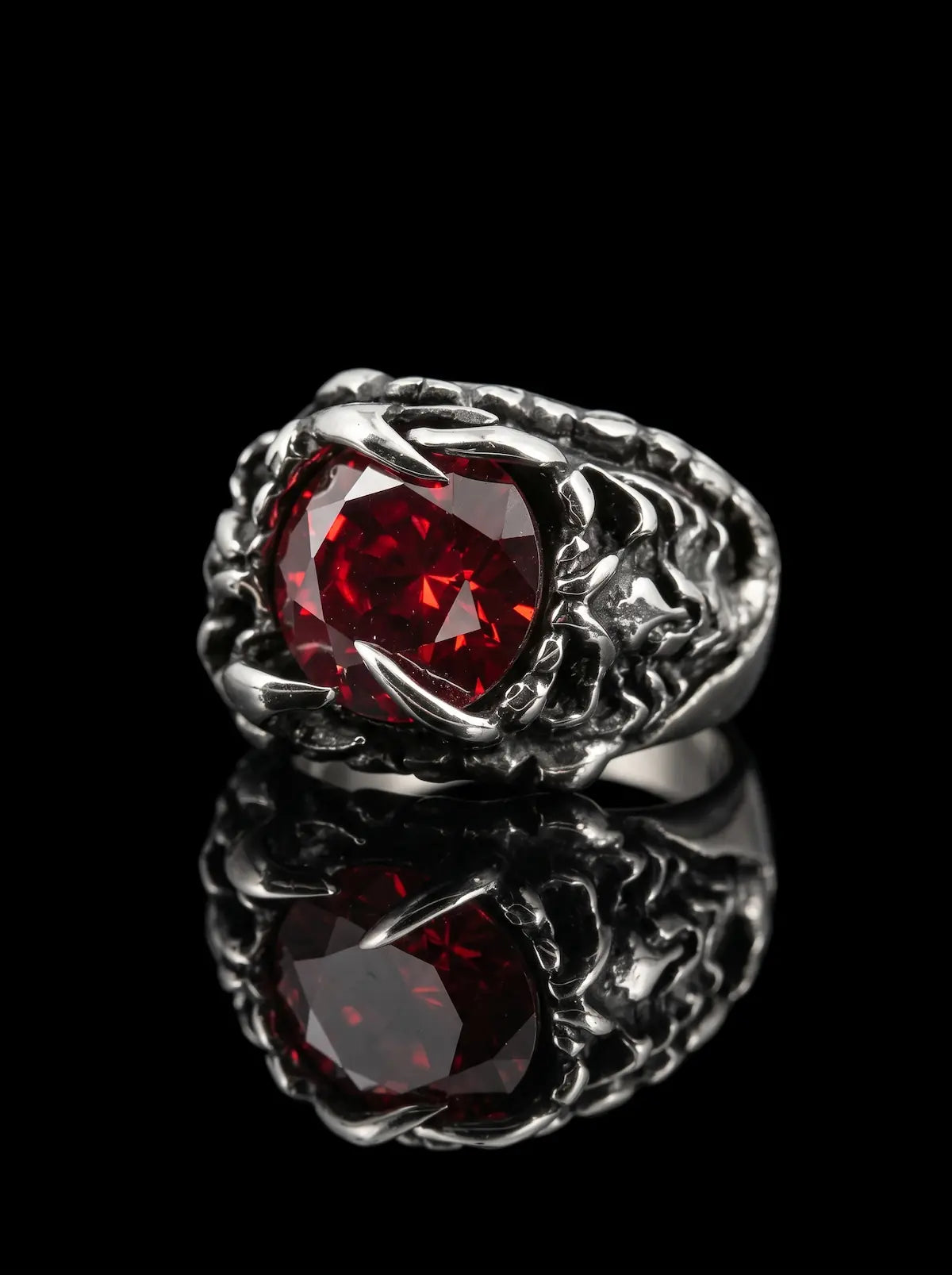 Dragon Talon Zircon Ring with a large red gemstone and claw setting on a black background