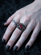 Hand wearing a Dragon Talon Zircon Ring with a large red gemstone and gothic claw setting