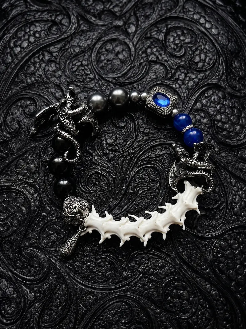 Duskdrake Snake Bone Bracelet, curved white vertebrae bracelet with dark metalwork and bright cobalt beads