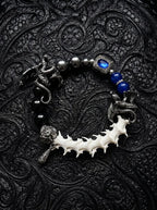 Duskdrake Snake Bone Bracelet, curved white vertebrae bracelet with dark metalwork and bright cobalt beads