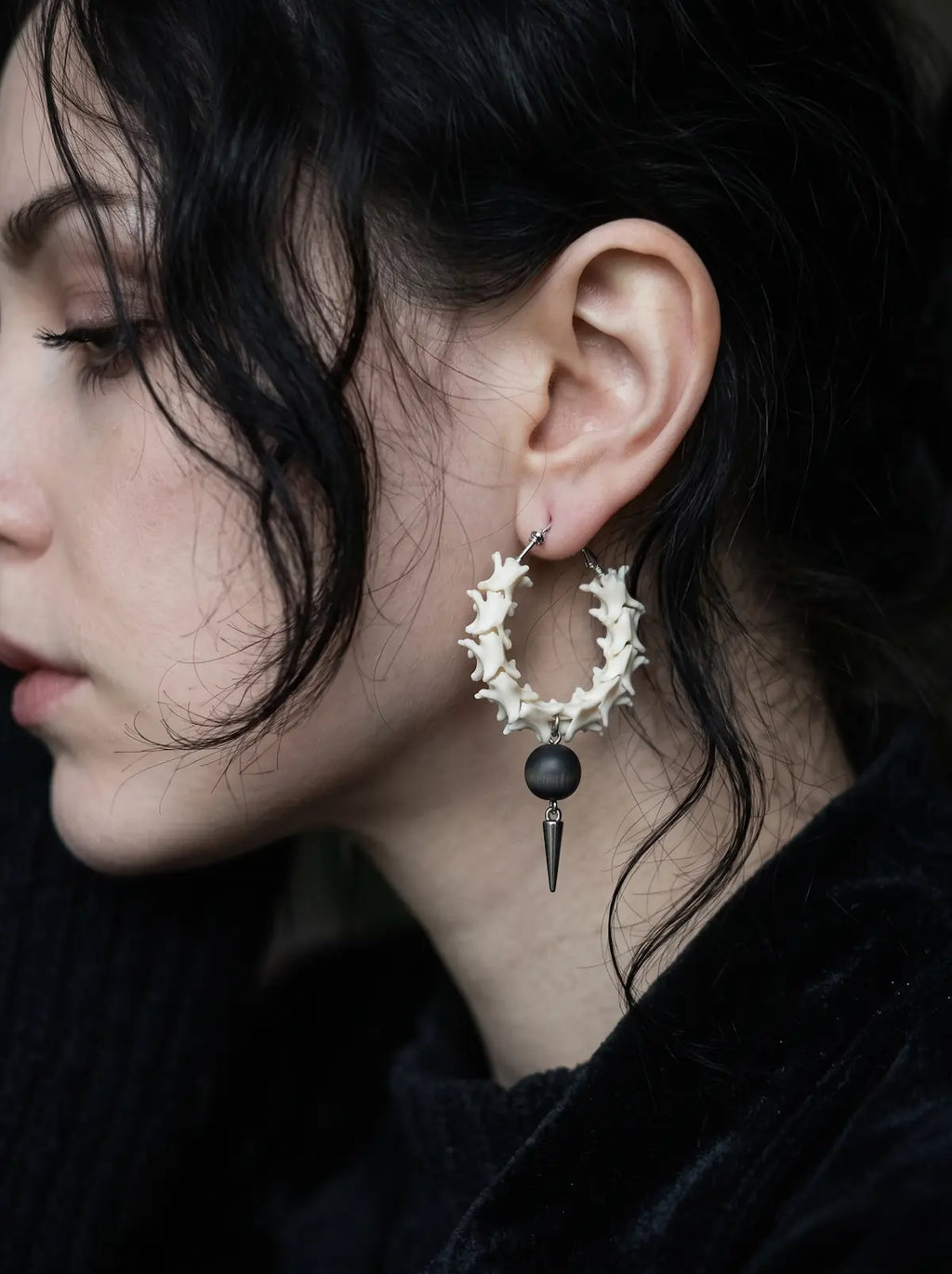 Ebon Thorn snake bone hoop earring shown in profile with its black bead and spike against the neck