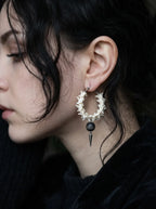 Ebon Thorn snake bone hoop earring shown in profile with its black bead and spike against the neck