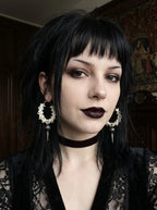 Ebon Thorn snake bone earrings worn with black lace and a velvet choker in a three-quarter portrait