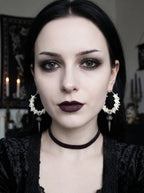 Ebon Thorn snake bone hoop earrings worn as a pair with a black choker in a front-facing portrait
