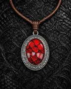 Eclipse Relic snakeskin pendant necklace in Blood Crimson, with a silver-tone oval frame and brown braided cord