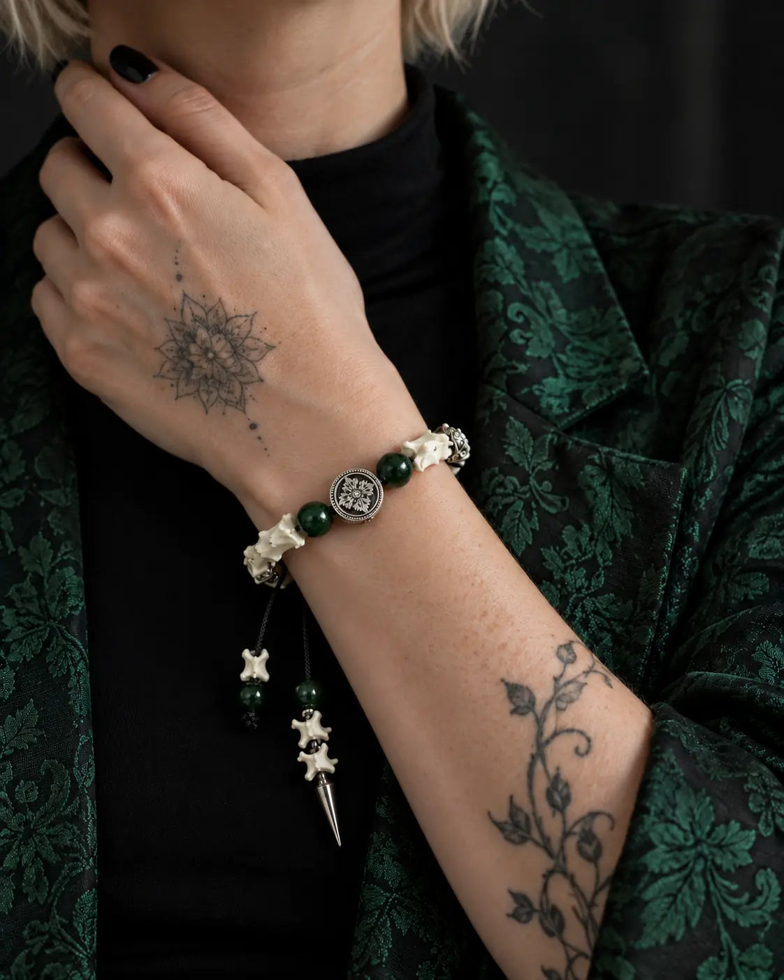 Emerald Thorn snake bone bracelet worn with the hand at the neck and its bone-and-spike cord end hanging down