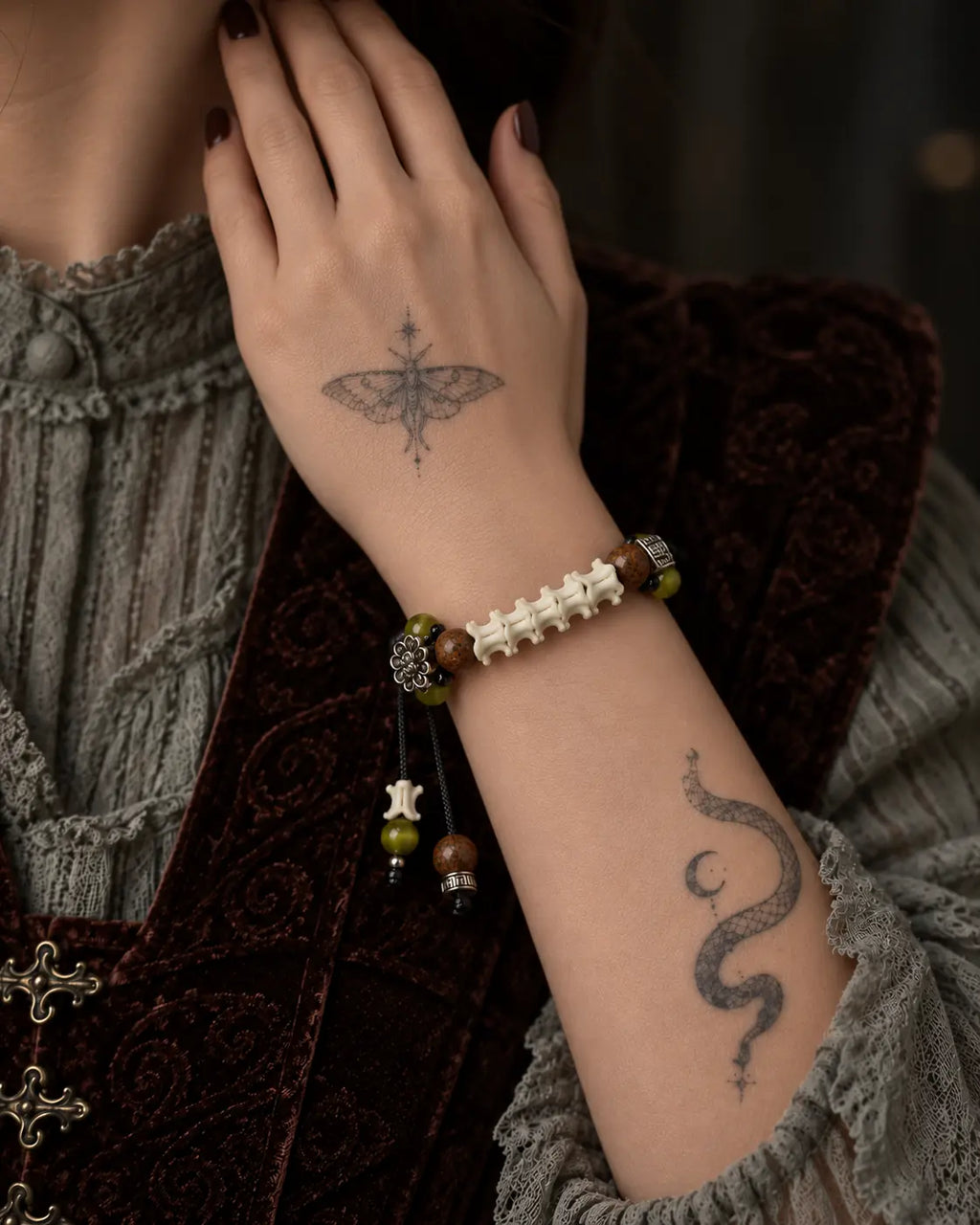 Forest Bloom snake bone bracelet worn with the hand near the neck, showing beaded cord ends