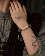 Forest Bloom snake bone bracelet worn with the hand near the neck, showing beaded cord ends