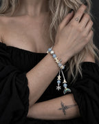 Frost Tide snake bone bracelet worn with the hand near the collarbone above a black neckline