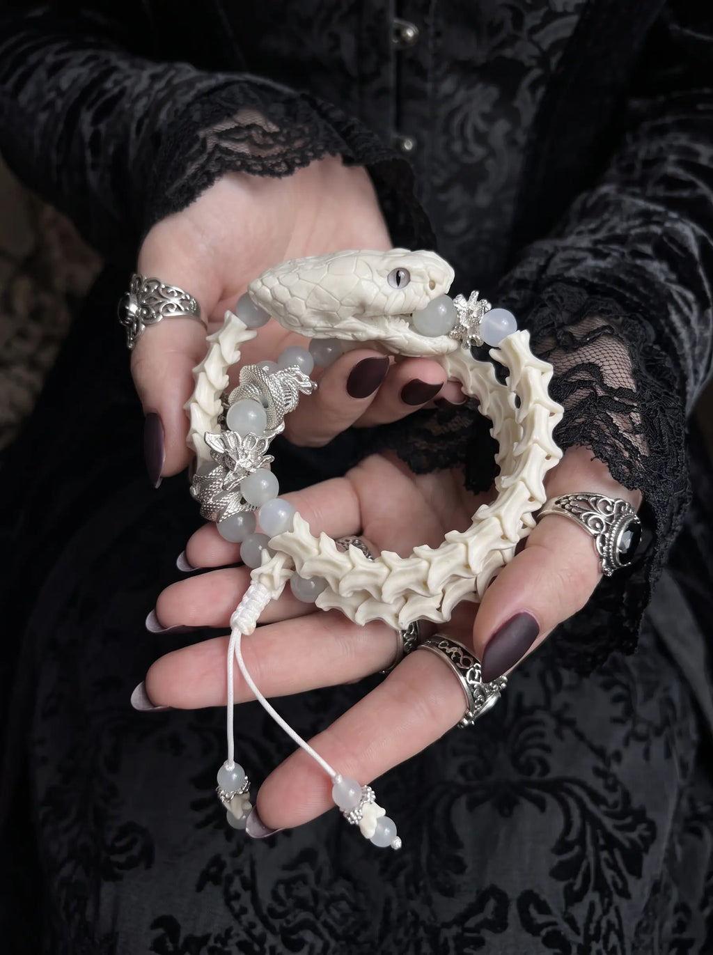 Ghostcoil Snake Bone Bracelet, pale preserved snake head and spiral bone bracelet held across both hands