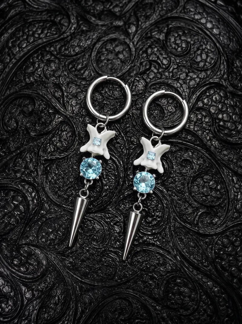 Glacial Spike Snake Bone Earrings, pair of pale vertebrae earrings with icy blue beads, star ornaments and metal points