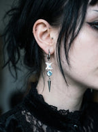 Glacial Spike Snake Bone Earrings, pale bone earring with light blue bead and long silver-tone spike worn at the ear