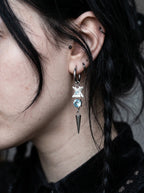 Glacial Spike Snake Bone Earrings, side ear detail showing pale vertebrae, icy bead and star pendant